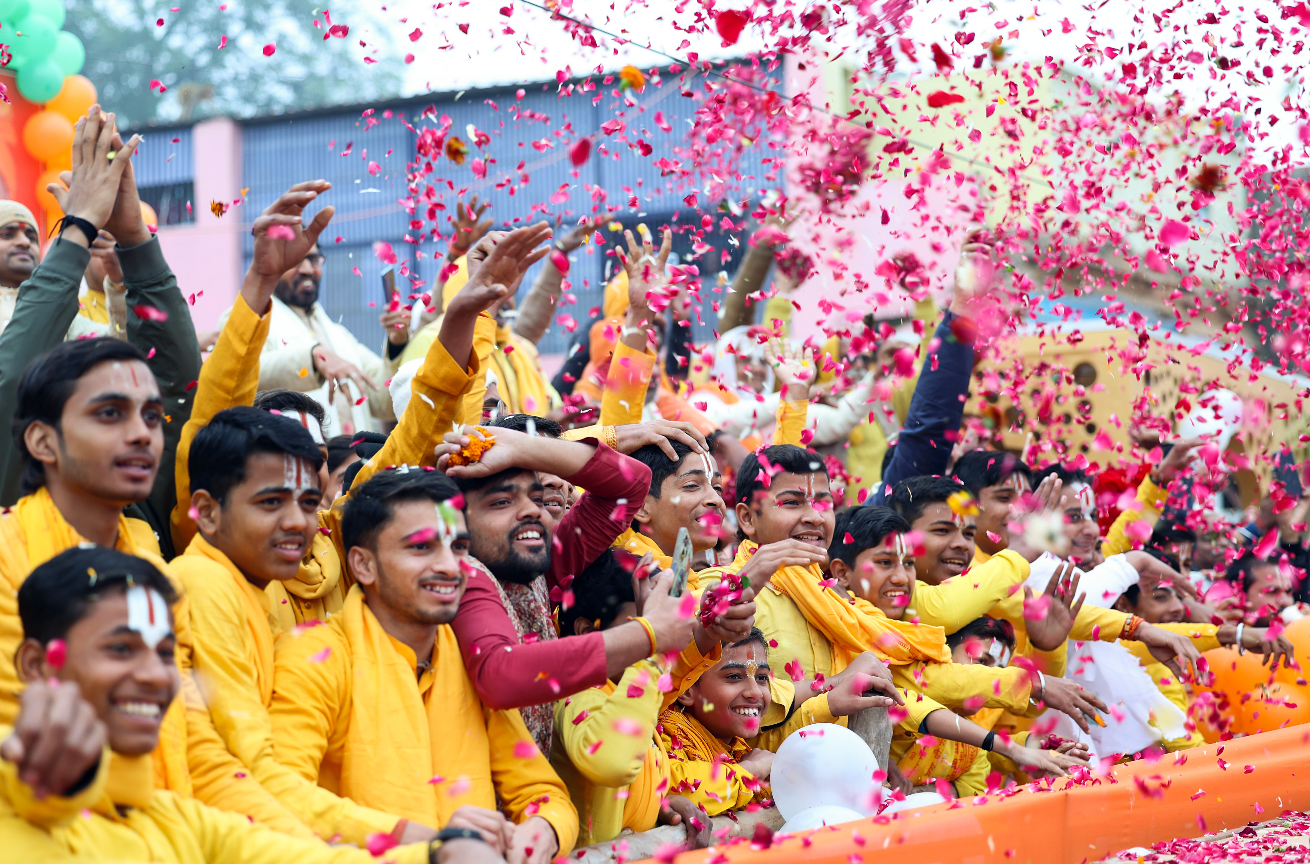 People warmly welcome Prime Minister Narendra Modi (unseen) as he holds a roadshow upon his arrival in Ayodhya on Saturday.