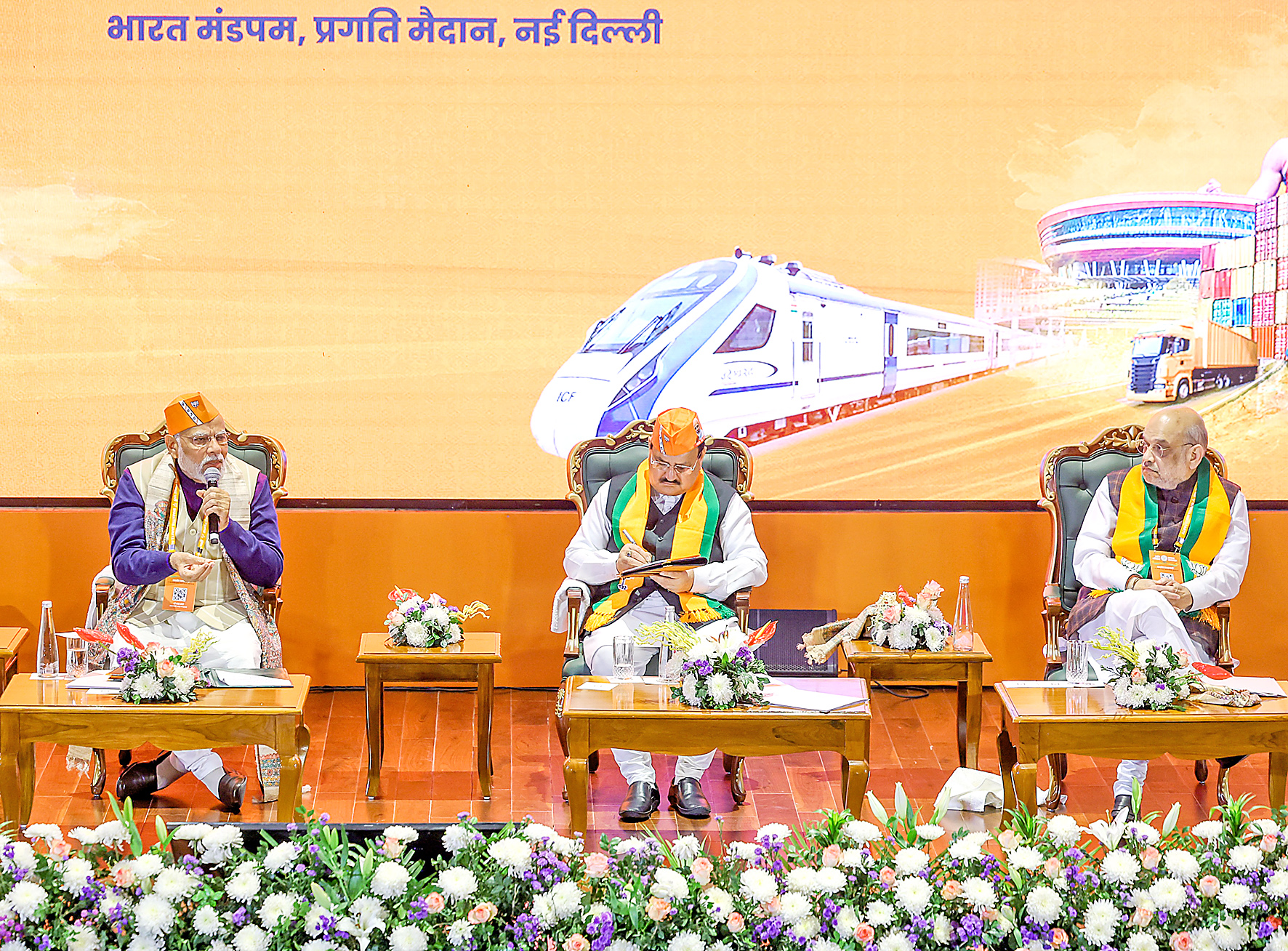 PM Modi addresses the meeting as Amit Shah and JP Nadda look on.