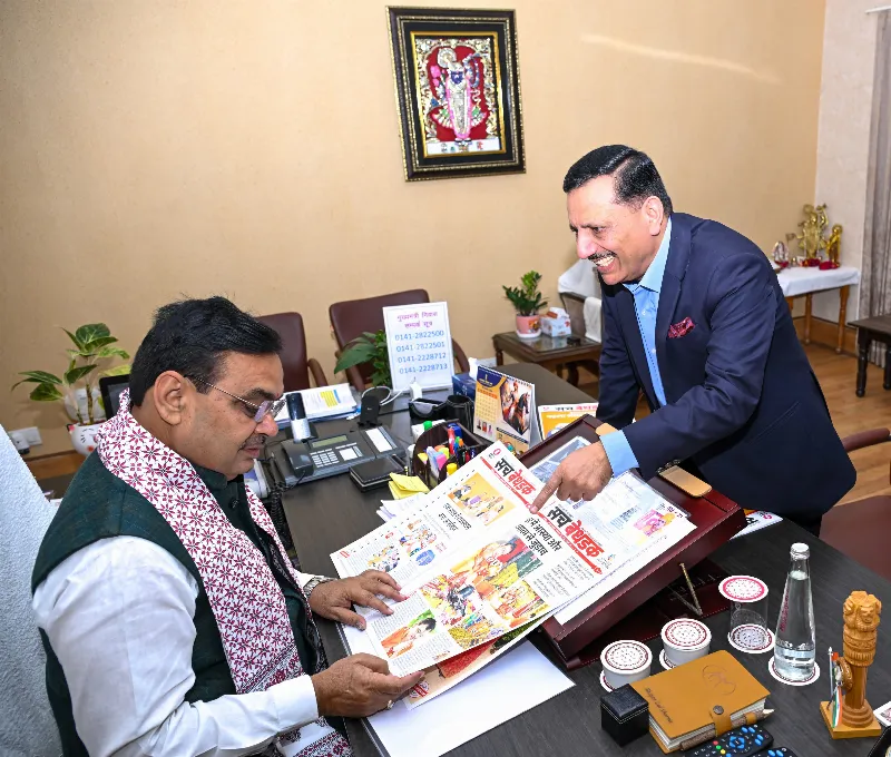 CM Bhajan Lal Sharma looks intently as Pawan Arora draws his attention towards the innovative headline