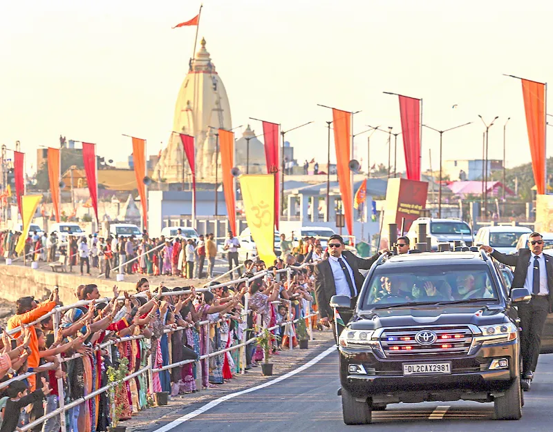 PM Narendra Modi waves to people from his car as he receives a warm welcome, in Gir Somnath on Saturday.